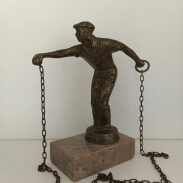 Statuette d'un homme tenant un poids à chaînes
