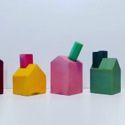 Cinq objets en forme de maison en bois peints en couleurs vives
