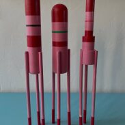 Trio de sculptures en bois rouges et roses